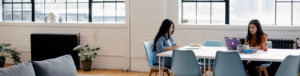two-women-sitting-on-a-desk